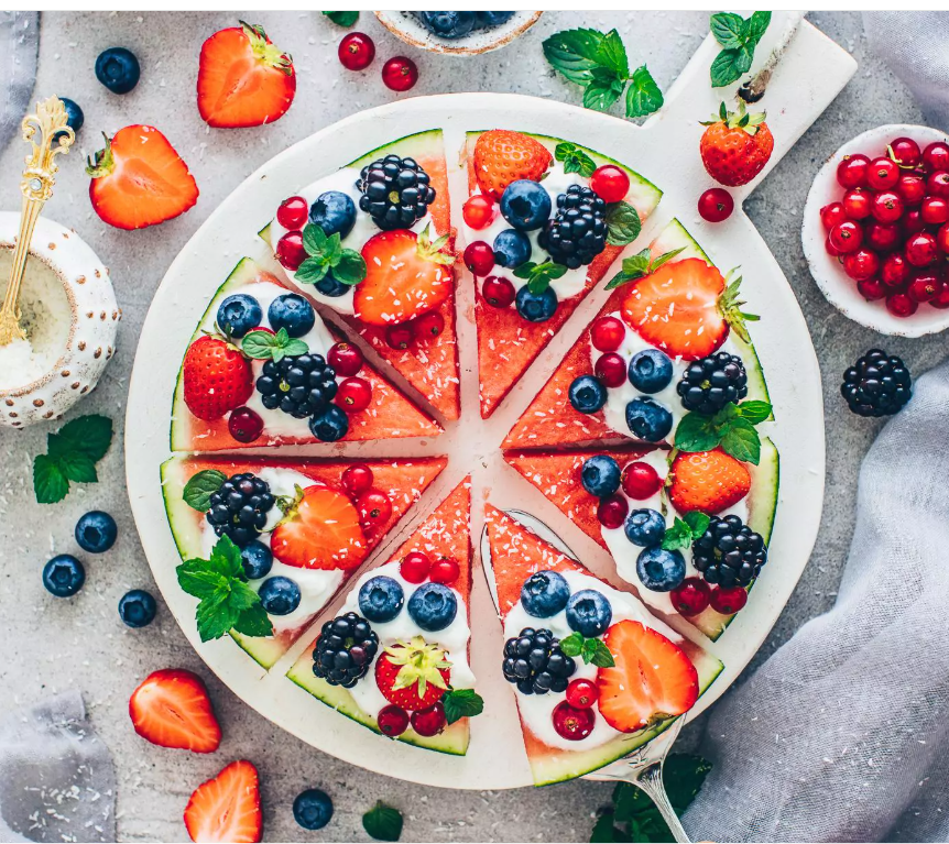 Watermelon fruit pizza slices topped with yogurt and fresh berries